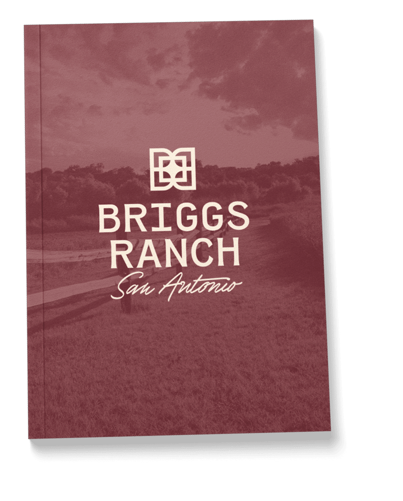 Maroon book cover with a landscape background, featuring "Briggs Ranch San Antonio" and a geometric logo in white text—highlighting new homes for sale in the scenic Medina Valley.