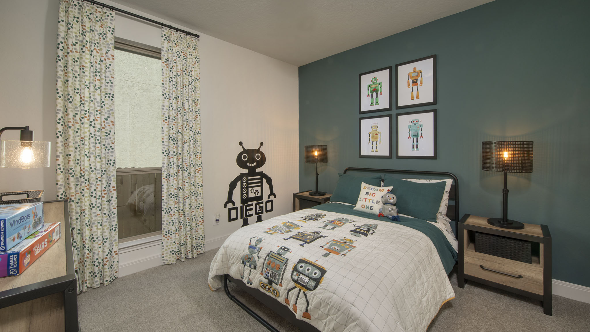 Childrens bedroom with robot decor, teal accent wall, and a bed with robot-themed bedding.