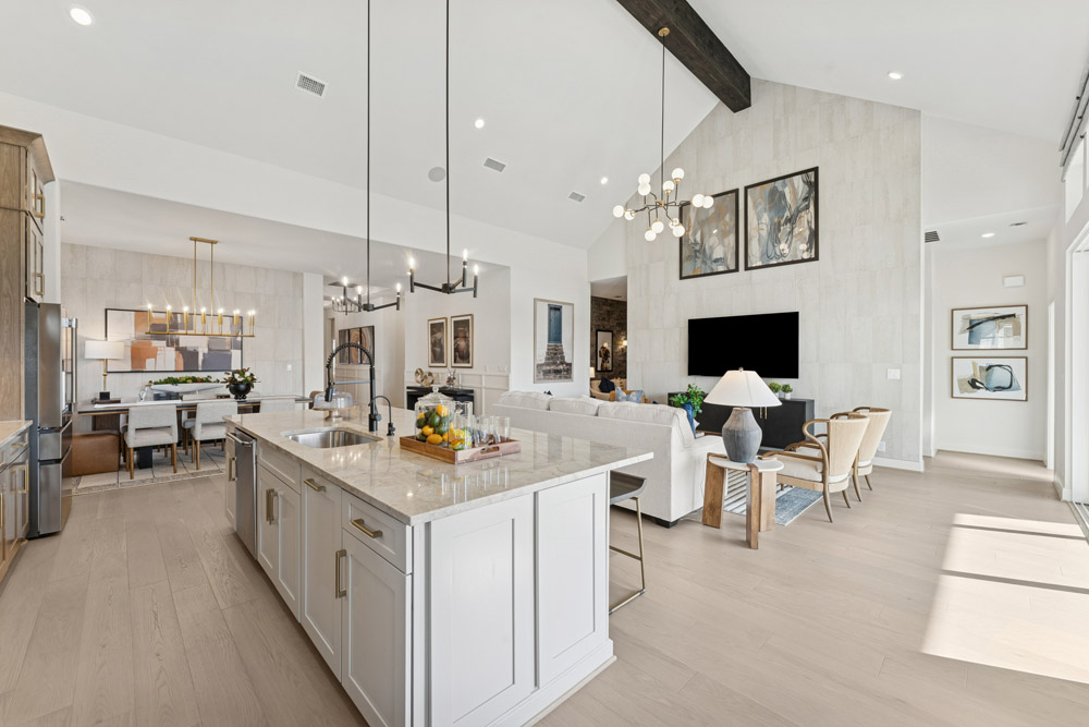 Modern open-concept kitchen and living room with high ceilings and neutral decor.