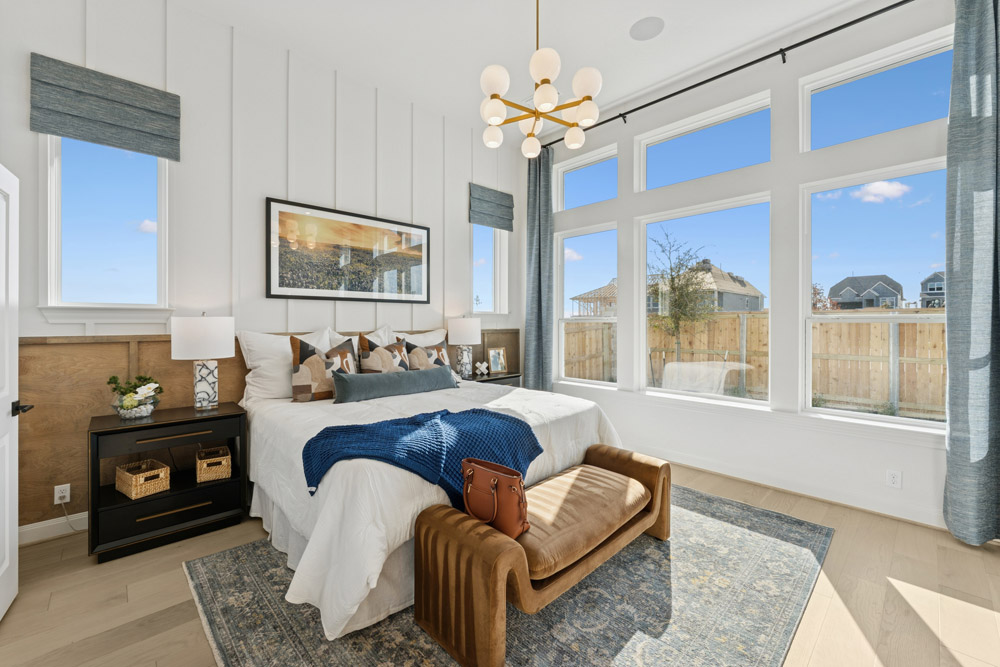 Modern bedroom with large windows, a bed, a bench, and contemporary decor.