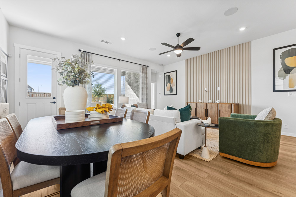 Modern living and dining area with wood accents, neutral tones, and large windows.