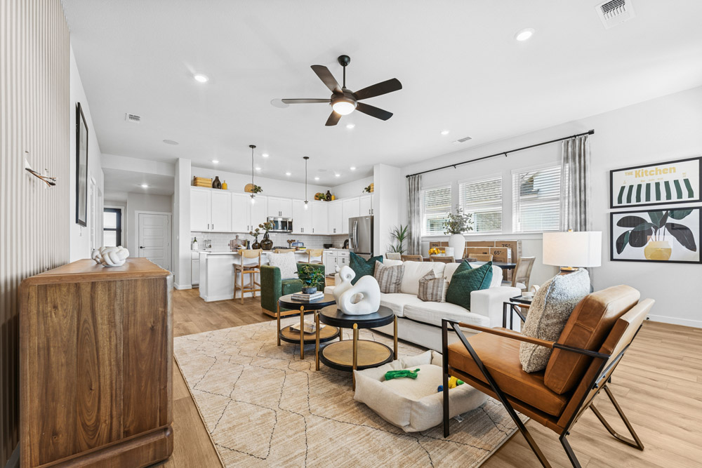 Modern open-concept living room and kitchen with neutral tones and contemporary decor.