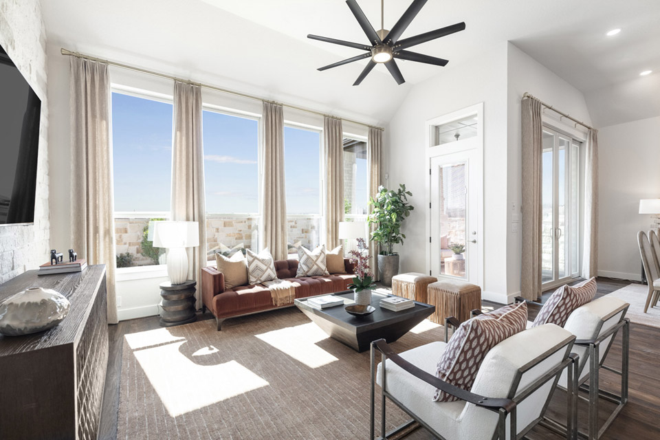 Bright living room with large windows, modern furniture, and neutral decor accents.