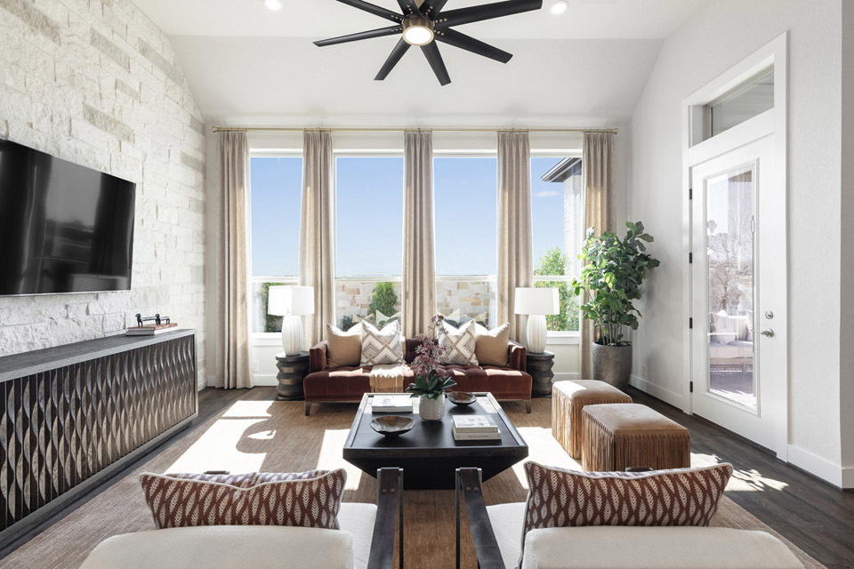 Modern living room with large windows, neutral decor, and contemporary furnishings.