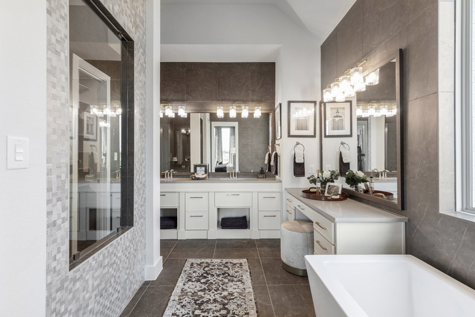 Modern bathroom with double sinks, large mirrors, and a freestanding bathtub.