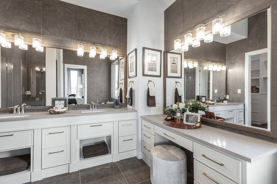 Modern bathroom with double sinks, large mirrors, and a vanity with stool.