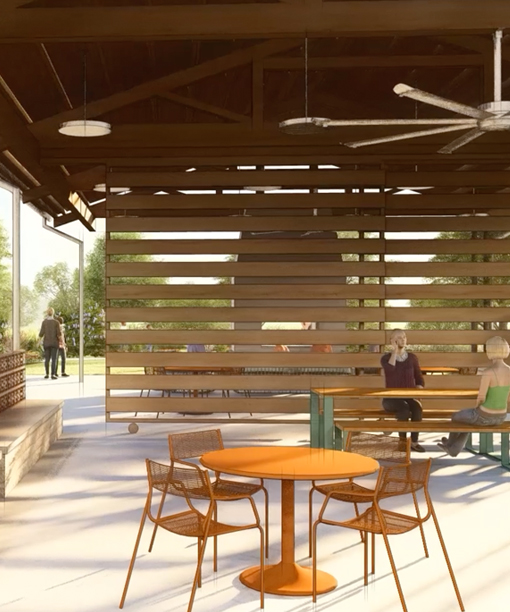 Outdoor covered seating area with round tables, wood slat wall, and people sitting on benches.